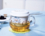 Taza de cristal con infusor de cerámica y tapa.